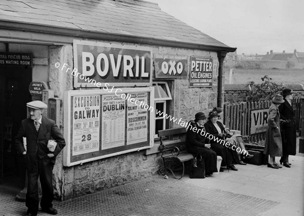 RAILWAY STATION WITH ADS FOR BOVRIL AND OXO